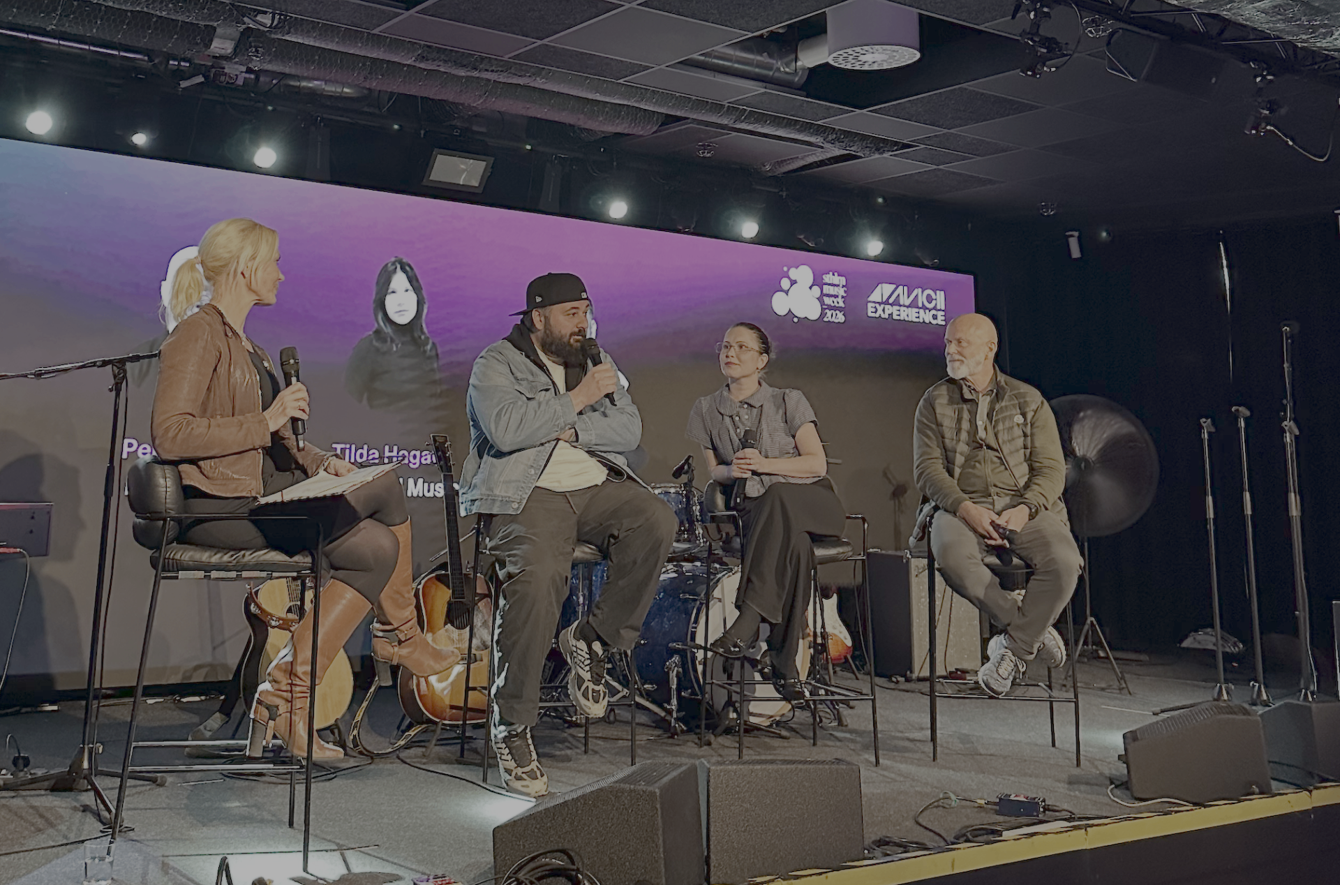 Four panelists seated on stage at The Node under purple lighting, with Tilda Hagel projected on the back screen alongside the Stockholm Music Week and Avicii Experience logos during the future of music panel.