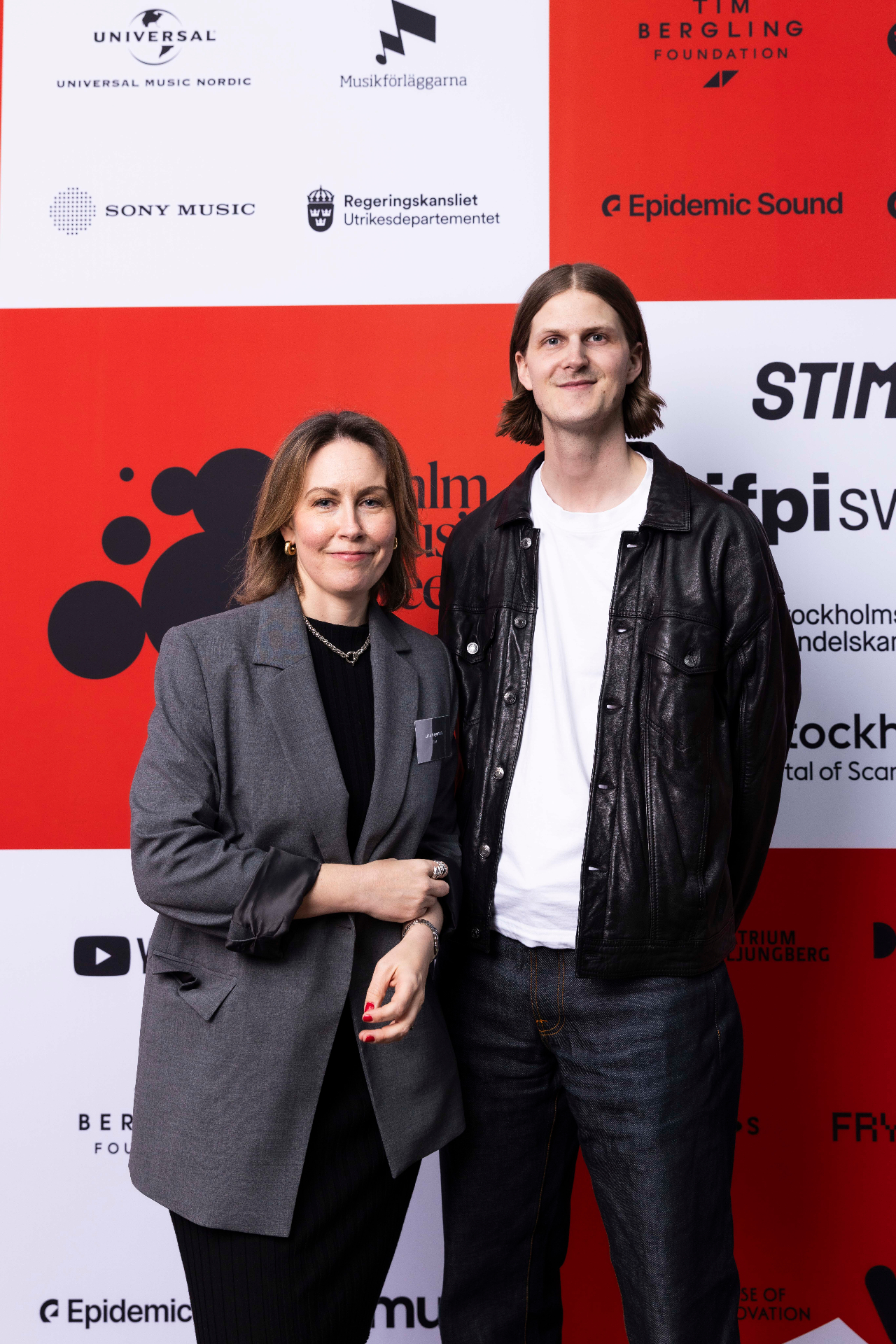 Lina Heyman and Simon Gozzi in front of the photo wall