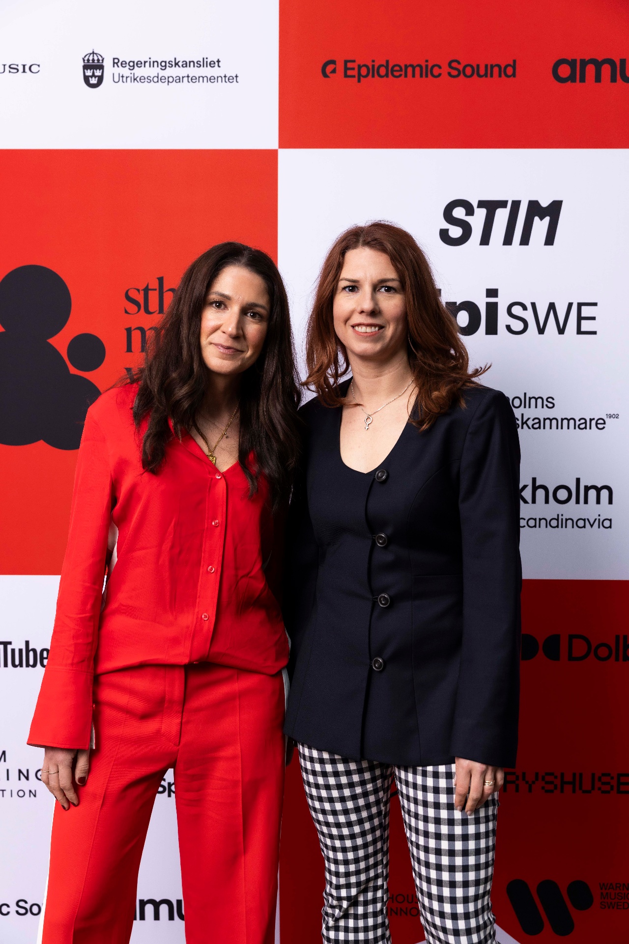 Negin Tagavi and Emilia Bjuggren in front of the photo wall