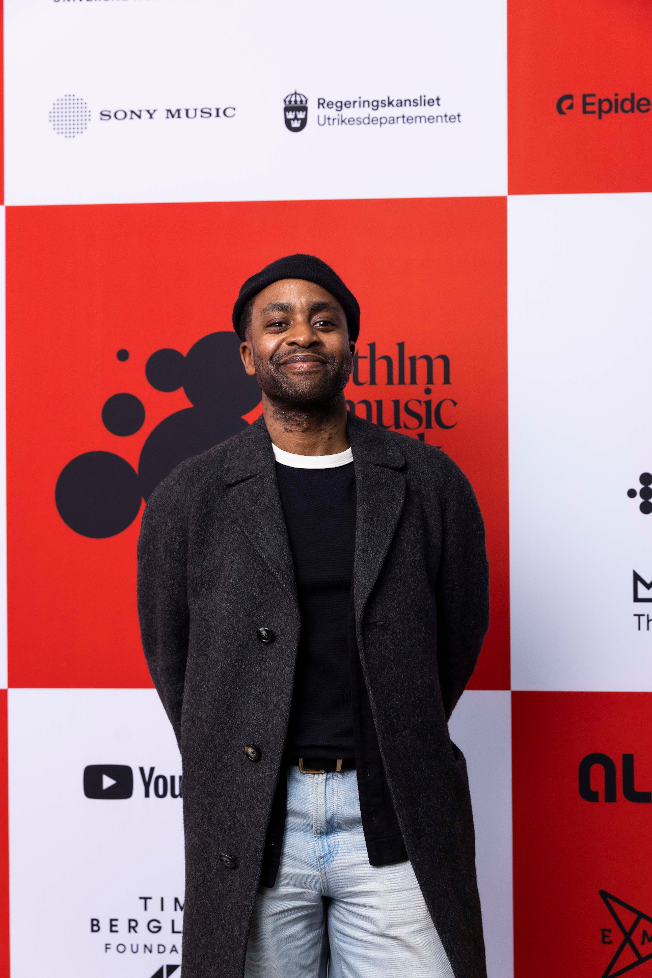 Paulo Saka in front of the photo wall